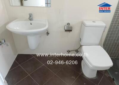 Bathroom featuring sink, toilet, and tiled floor