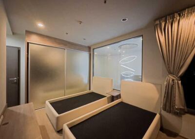 Modern bedroom with two beds and frosted glass door