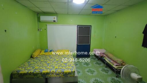 Bedroom with a green interior, a bed with yellow Minions-themed bedding, and a single bed next to it