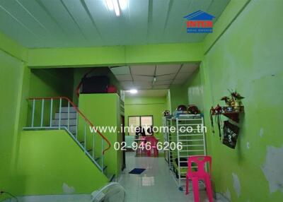 Main living space with bright green walls and stairs