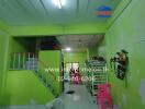 Main living space with bright green walls and stairs