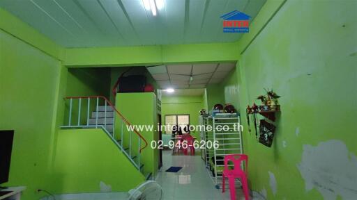 Main living space with bright green walls and stairs