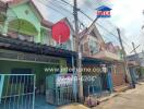 Exterior view of residential houses with colorful facades and a street perspective