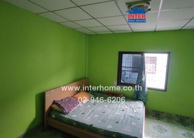 Bedroom with green walls and a bed with a green patterned cover