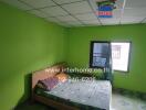 Bedroom with green walls and a bed with a green patterned cover