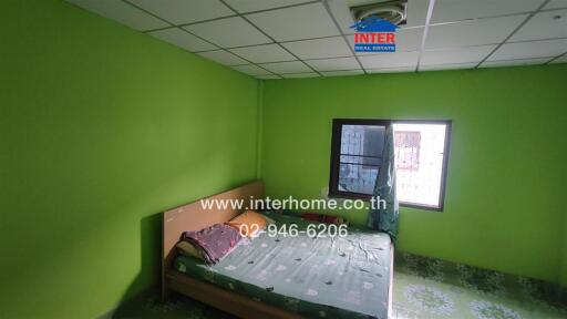 Bedroom with green walls and a bed with a green patterned cover