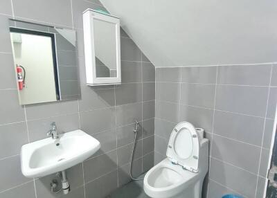 Modern bathroom with sink, mirror, toilet and a blue trash bin