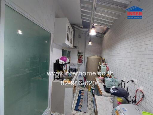 Small kitchen with white brick walls and modern appliances