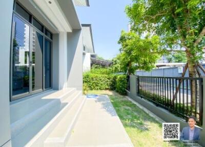 Bright exterior area with green lawn and trees