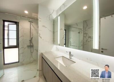 Modern bathroom interior with large mirror and marble accents