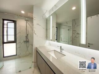 Modern bathroom interior with large mirror and marble accents