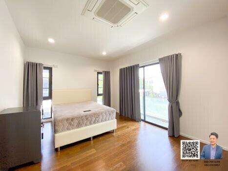 Spacious bedroom with a large window and modern furnishings