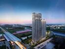 Aerial view of a modern high-rise residential building next to a transit station