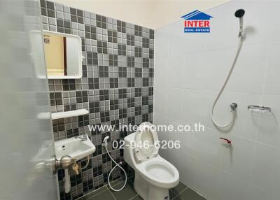 Bathroom with tiled walls, mirror, sink, toilet, and shower