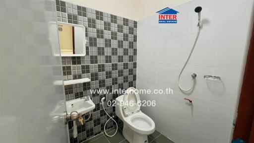 Bathroom with tiled walls, mirror, sink, toilet, and shower