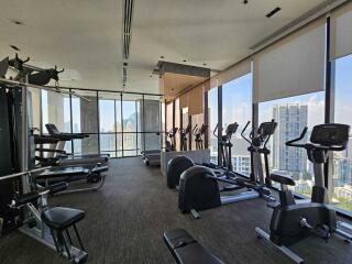 Modern gym with various exercise equipment and city views