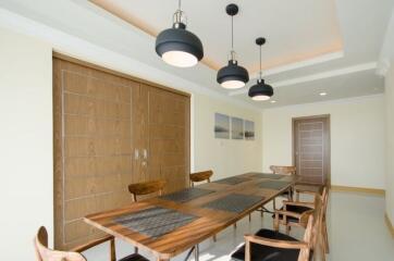 Stylish dining room with wooden table and modern pendant lights