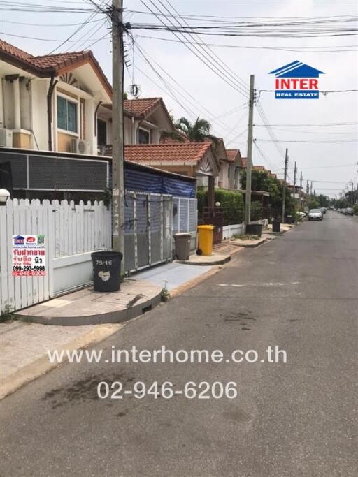 Residential street view with houses and real estate sign