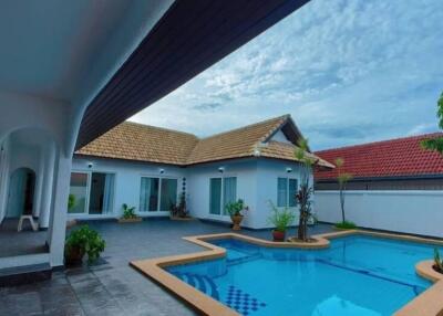 Outdoor area with swimming pool and house with tiled roof