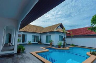Outdoor area with swimming pool and house with tiled roof