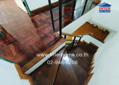 Wooden staircase leading upstairs with glass railing