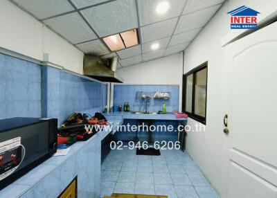 A view of the kitchen with blue tiling, modern appliances, and storage spaces.