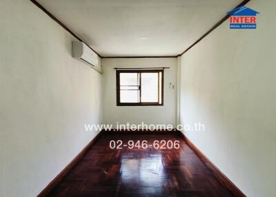 Simple empty bedroom with wooden floor and window