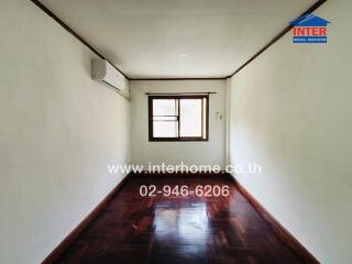 Simple empty bedroom with wooden floor and window