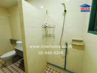 Bathroom with shower, toilet, and wall shelves