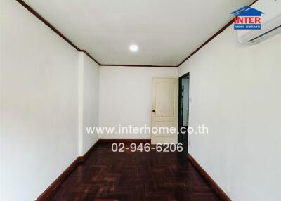 Empty room with wooden floor, white door, air conditioning, and ceiling light