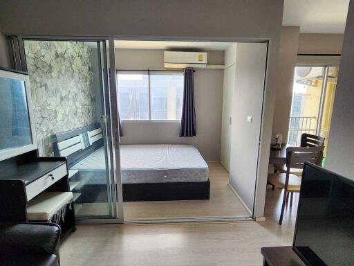 Compact bedroom with a sliding glass partition and adjacent dining area