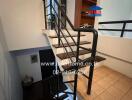 Staircase with metal railing and wooden steps