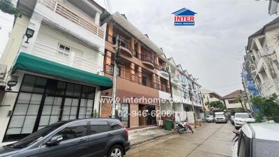 Street view of residential buildings with cars parked