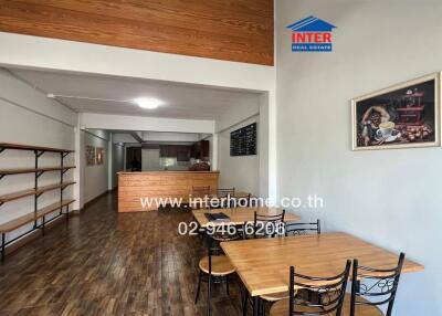 Dining area leading to kitchen with wooden furniture and open shelves