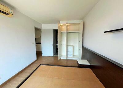 Empty bedroom with built-in wardrobe and open door to adjoining room