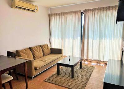 Living room with couch, coffee table, air conditioning, and dining table