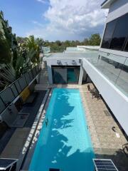 Modern outdoor pool with seating area and greenery