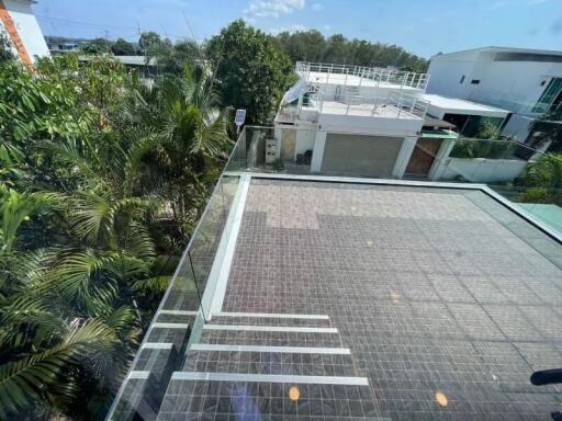 view from a balcony overlooking a tiled area and greenery