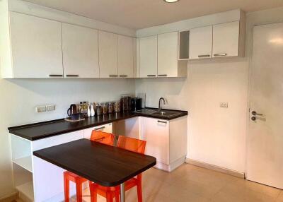 Modern kitchen with white cabinets and orange chairs