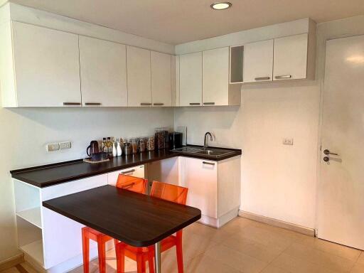 Modern kitchen with white cabinets and orange chairs