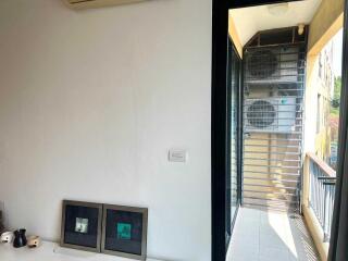 Small balcony area with air conditioning units and a view outside