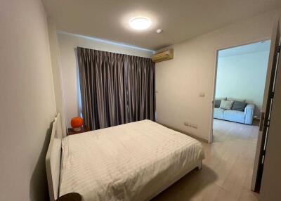 Spacious bedroom with large bed, air conditioning, and view into the living area