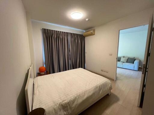 Spacious bedroom with large bed, air conditioning, and view into the living area