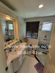 Modern bathroom with shower area, vanity, and large mirror