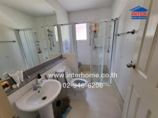 Bathroom with sink, mirror, shower area and toilet