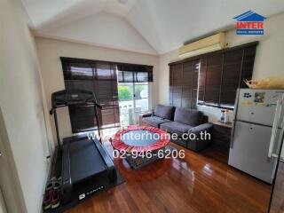 Living room with treadmill, couch, and refrigerator