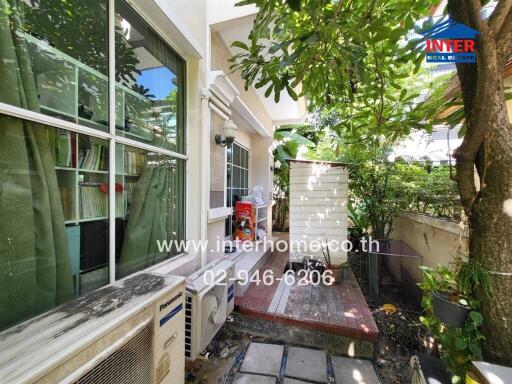 Outdoor area with green plants, air conditioning unit, and small deck