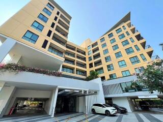 Modern multi-story residential building with parking area