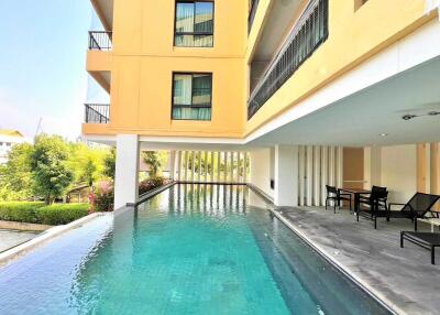 Outdoor swimming pool next to building with balcony view