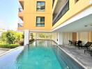 Outdoor swimming pool next to building with balcony view